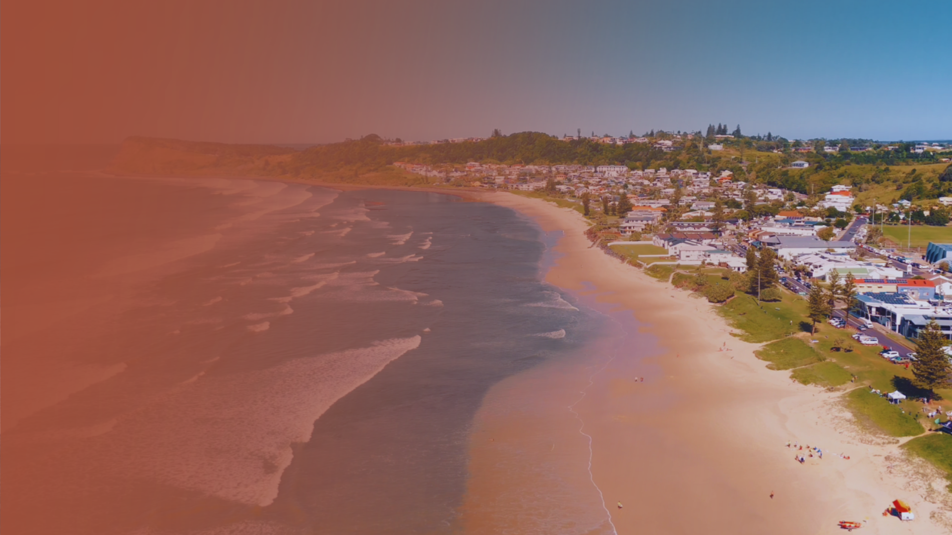 Aerial view of a Northern Rivers beach, headland and coastal township